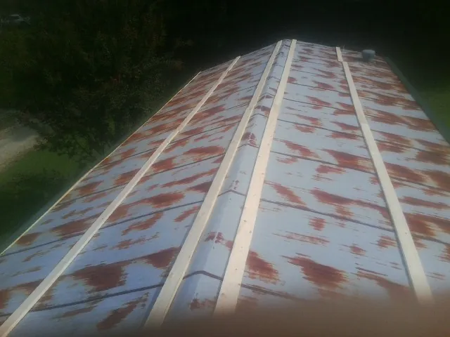 Rusted metal roof panels with new wood purlins before replacement — Storm Damage Roof Repair in Centre Hall by Roofing Brothers