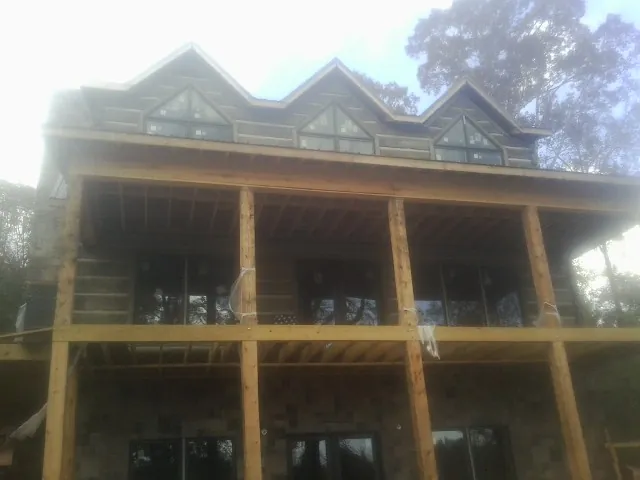 Dormers and porch framing on a large log home under construction — Roof Coating work by our crew in Centre Hall