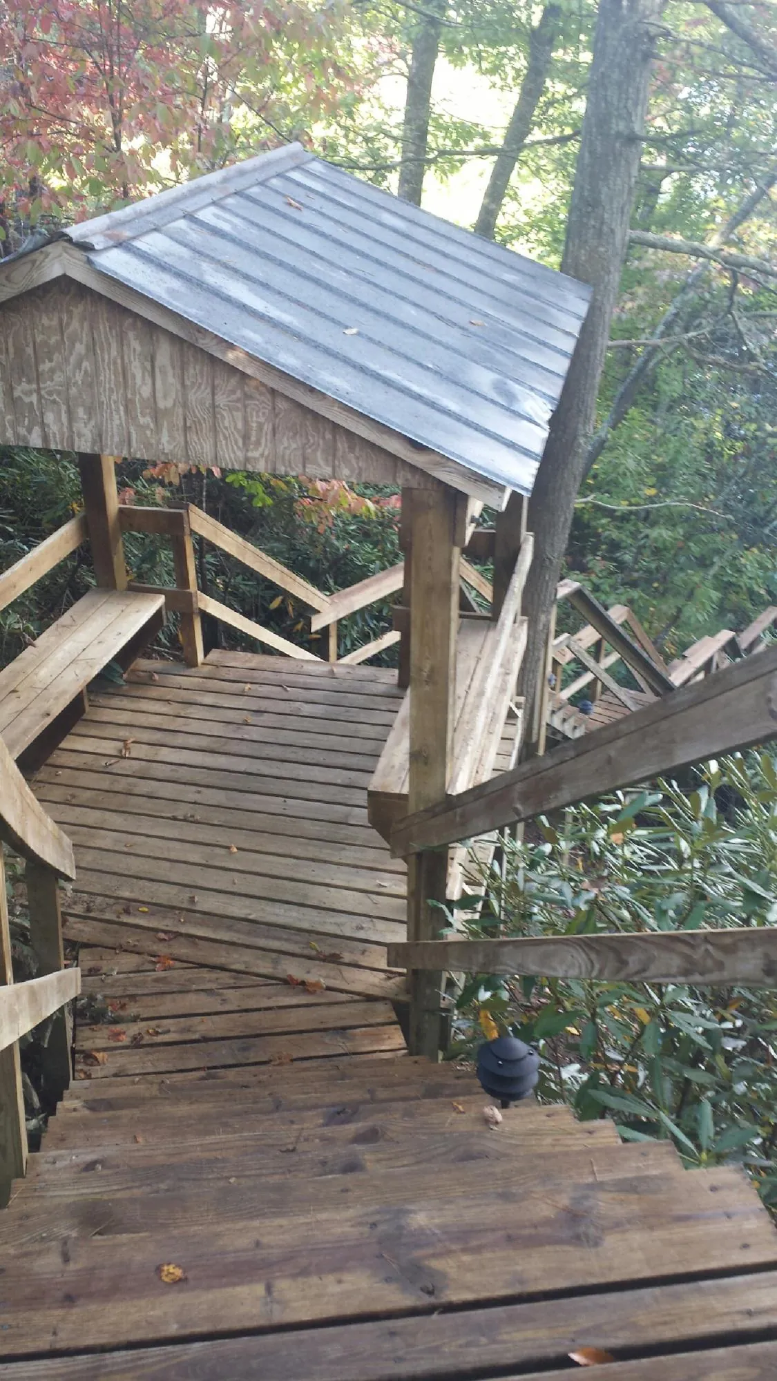 Metal roofed shelter over wooden steps on a wooded walkway — Skylight Repair & Installation work by our crew in Centre Hall