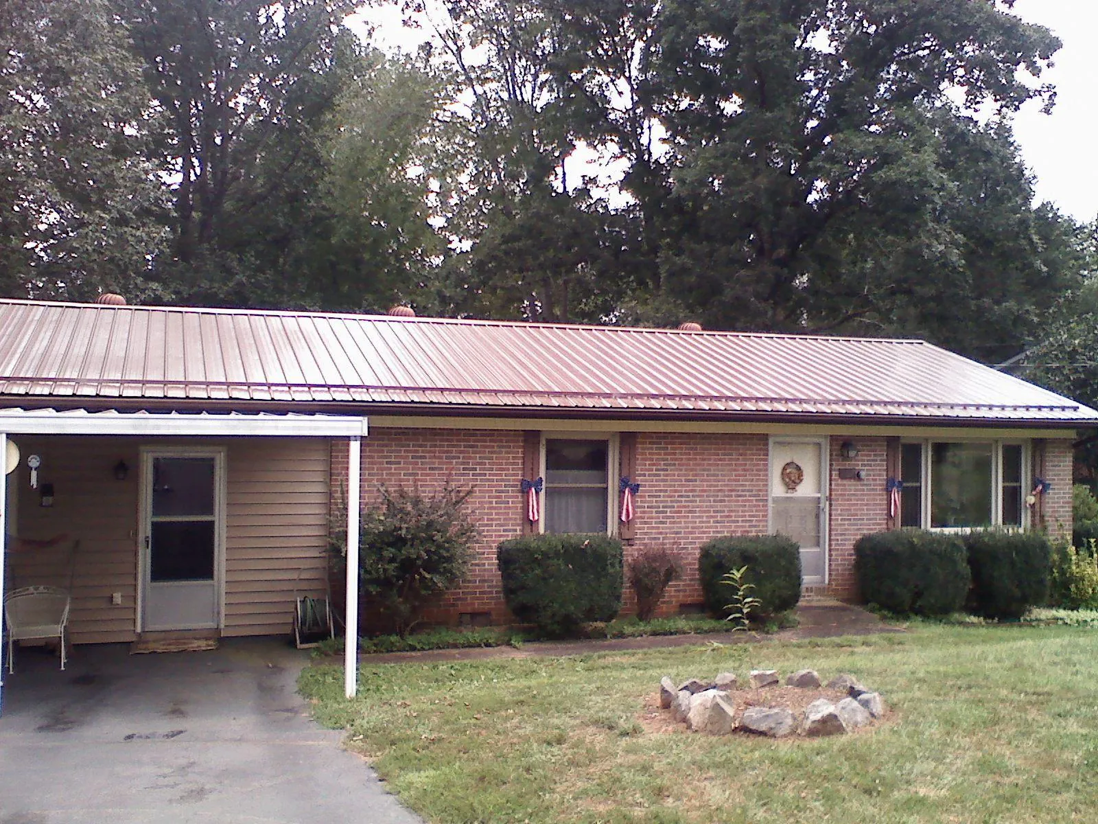 Bronze metal roof and carport on a brick ranch home — Roof Repair work by our crew in Centre Hall